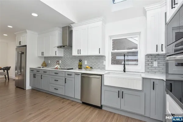 a kitchen with white cabinets sink and stainless steel appliances