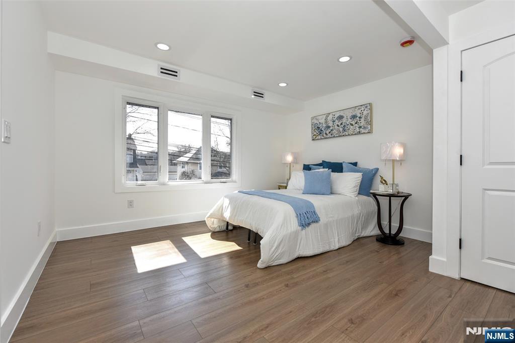 100 Chestnut Street Rochelle Park, NJ 07662 - Photo 16 of 42 a spacious bedroom with a bed and wooden floor