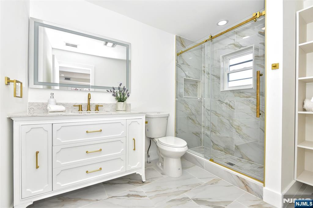 100 Chestnut Street Rochelle Park, NJ 07662 - Photo 17 of 42 a bathroom with a sink a toilet a mirror and shower