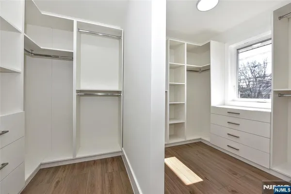 a view of walk in closet with wooden floor