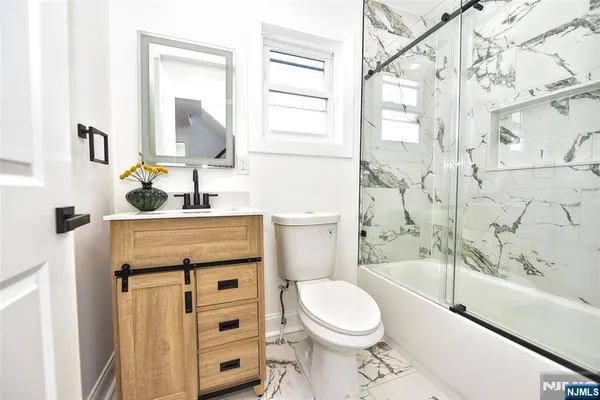 a bathroom with a granite countertop toilet sink and mirror