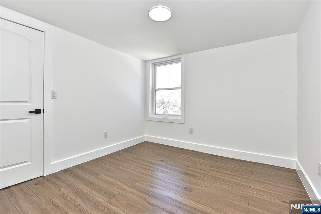100 Chestnut Street Rochelle Park, NJ 07662 - Photo 25 of 42 an empty room with wooden floor and windows