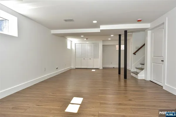 a view of an empty room with wooden floor and a large window