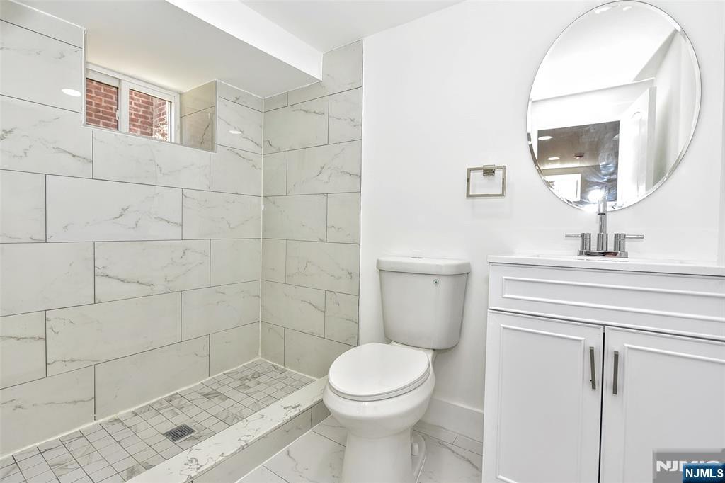 100 Chestnut Street Rochelle Park, NJ 07662 - Photo 29 of 42 a bathroom with a sink a toilet and mirror