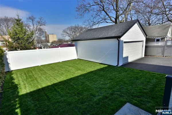 a view of a house with a yard potted plants and large tree
