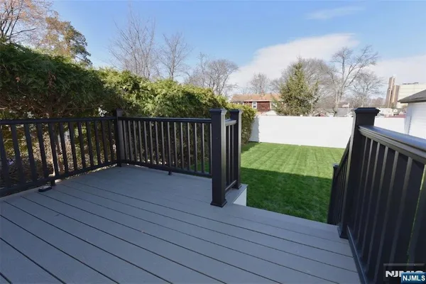 a view of deck with wooden floor and fence next to a yard