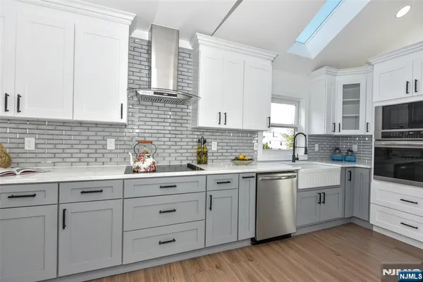 a kitchen with cabinets stainless steel appliances a sink and a window
