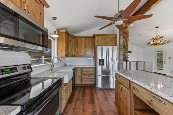 a kitchen with a refrigerator and a stove top oven