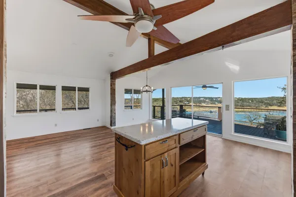 a living room with stainless steel appliances kitchen island granite countertop a stove and a large window