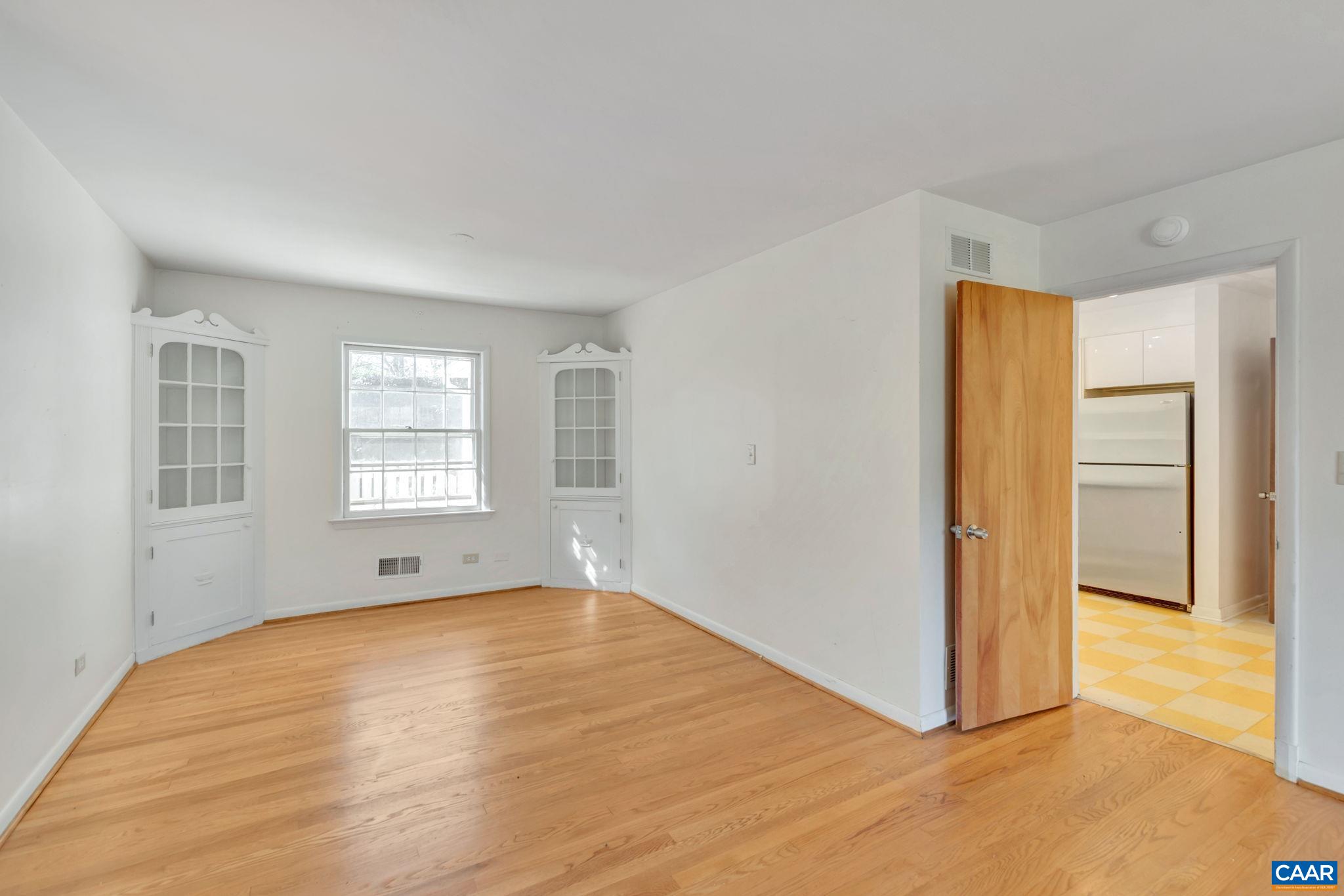 1406 Holly Road Charlottesville, VA 22901 - Photo 12 of 62 a view of an empty room with wooden floor and a window