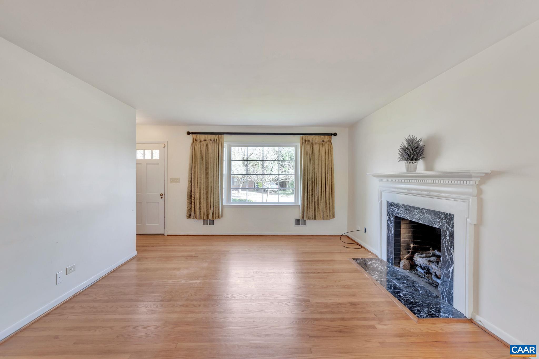 1406 Holly Road Charlottesville, VA 22901 - Photo 13 of 62 a view of an empty room with exposed radiator and fireplace