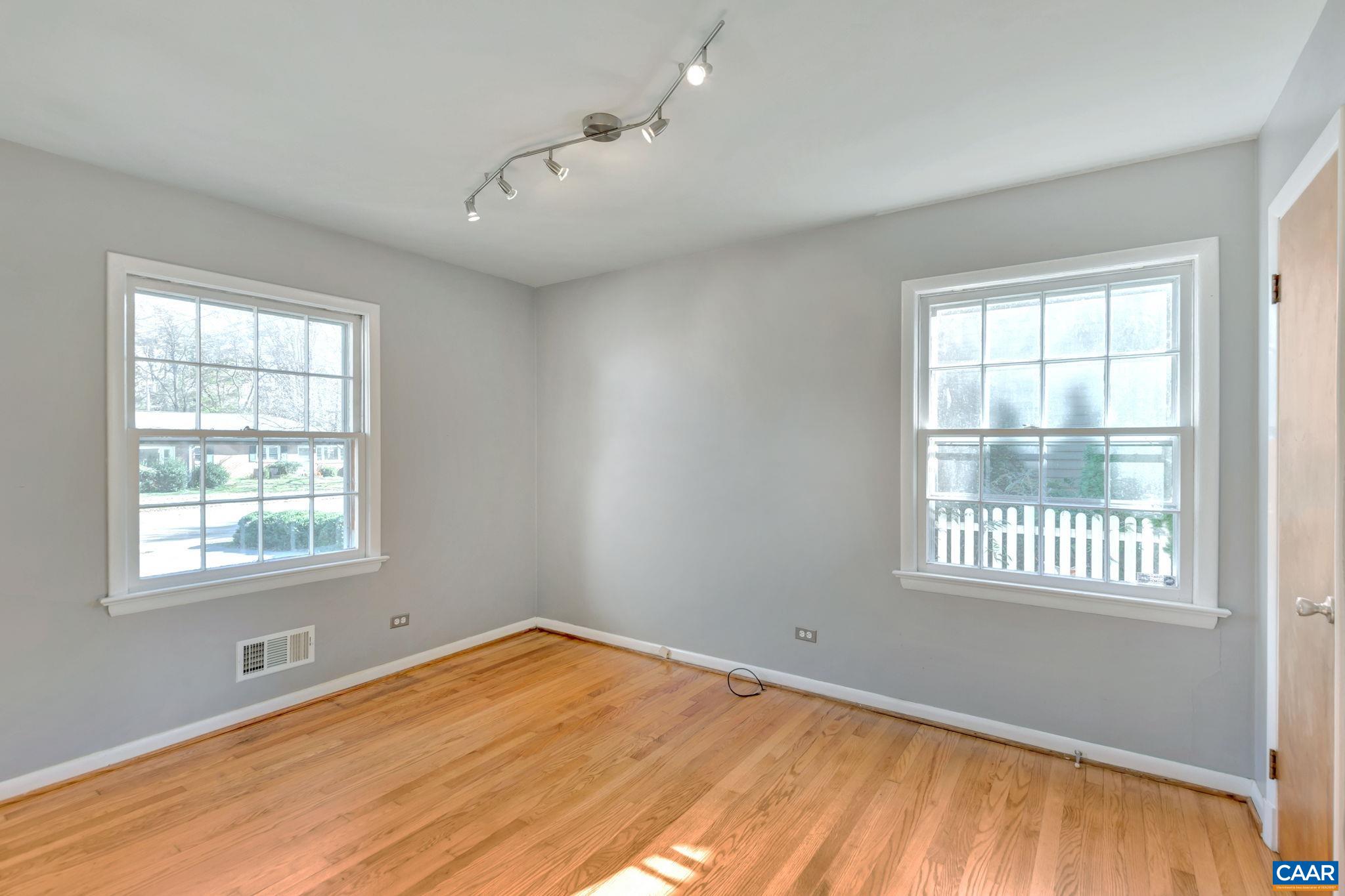 1406 Holly Road Charlottesville, VA 22901 - Photo 16 of 62 a view of an empty room with wooden floor and a window
