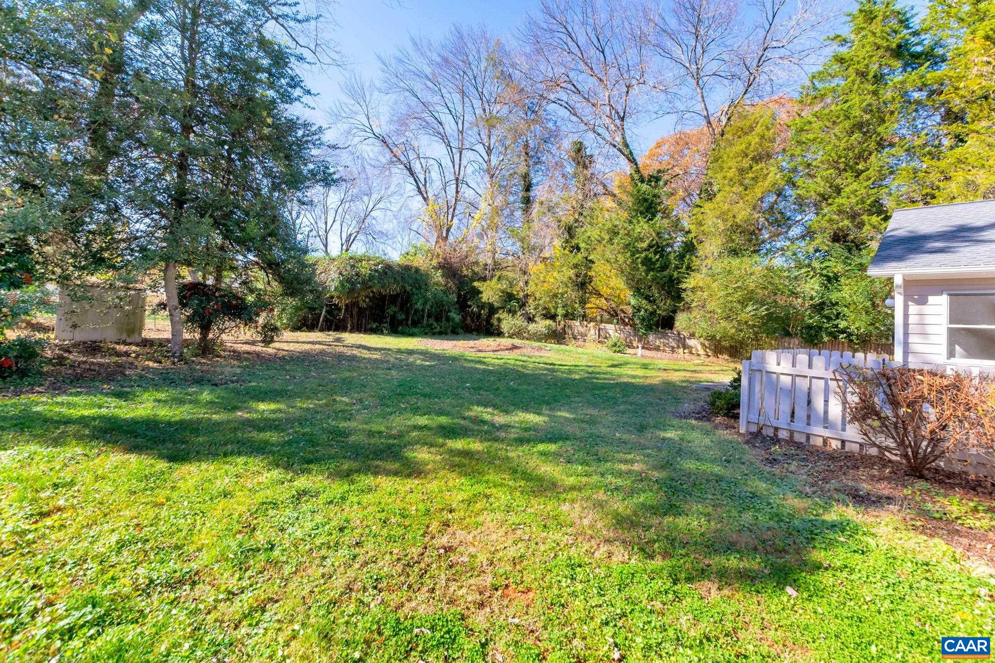 1406 Holly Road Charlottesville, VA 22901 - Photo 57 of 62 a backyard of a house with lots of green space and fountain