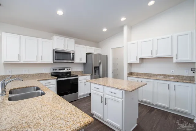 a kitchen with a sink stove top oven and refrigerator