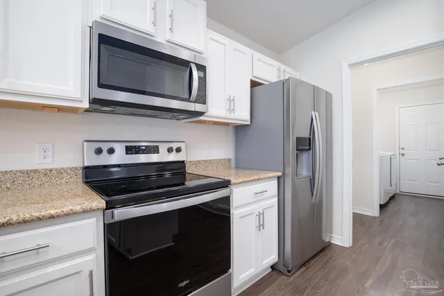 a kitchen with stainless steel appliances a stove microwave and refrigerator