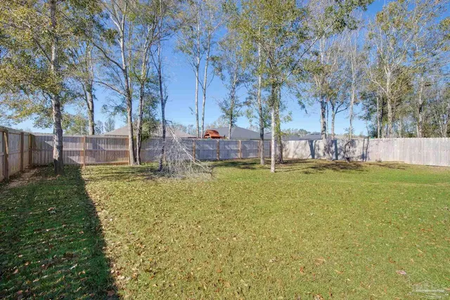 a view of a backyard with table and chairs and wooden fence