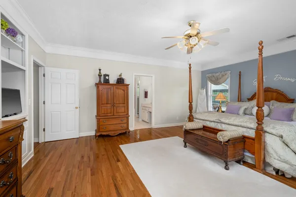 a spacious bedroom with a bed and a flat screen tv