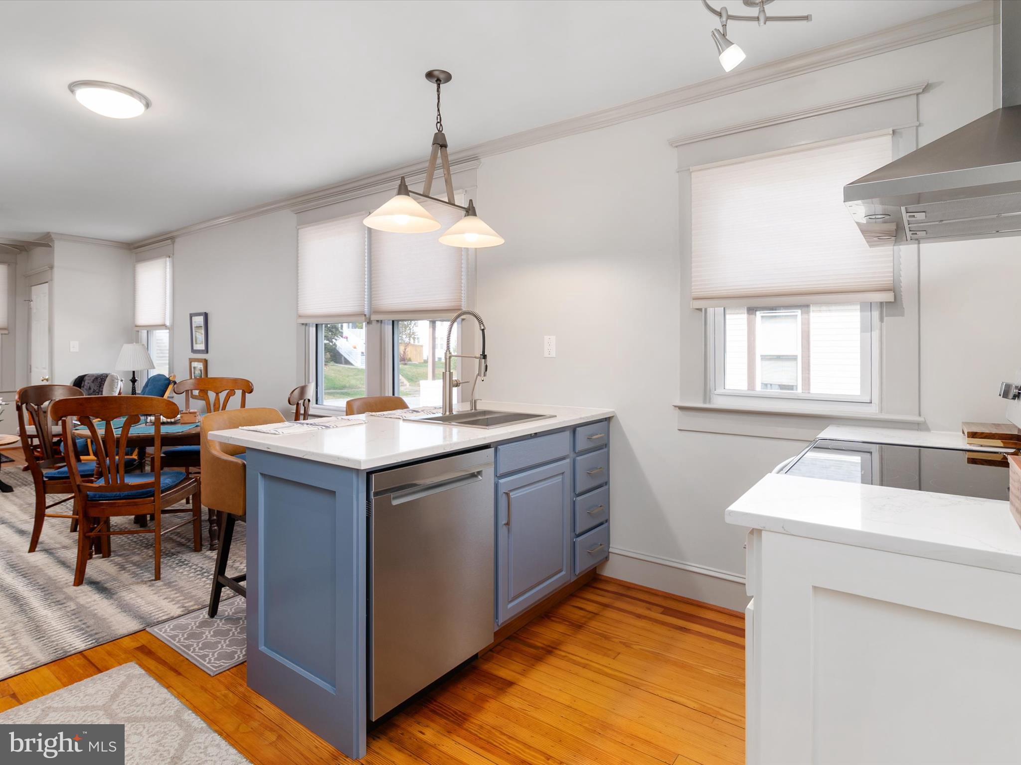 3669 Hineline Road Baltimore, MD 21229 - Photo 13 of 33 a kitchen with stainless steel appliances granite countertop a sink dishwasher a stove a dining table and chairs with wooden floor