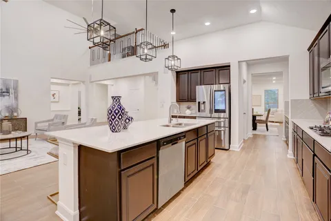 a large kitchen with a center island and stainless steel appliances