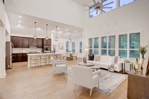 a living room with fireplace furniture and a large window