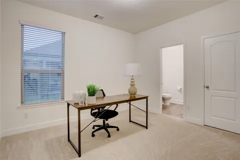 a view of a workspace with furniture and a window