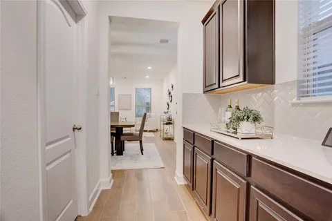 a hallway with white cabinets and white appliances