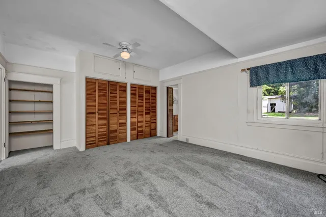 a view of a kitchen with refrigerator and white cabinets