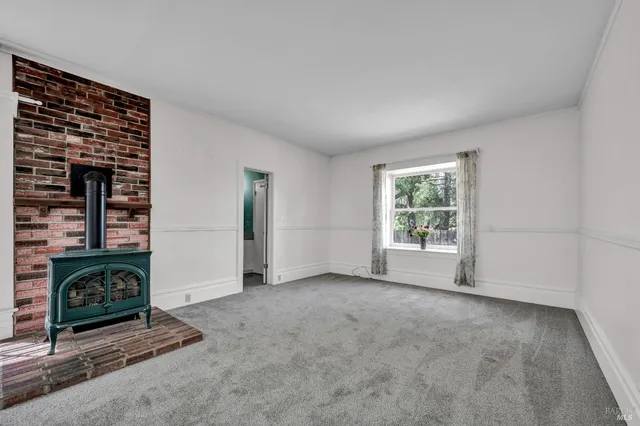 a view of a livingroom with an empty space and a window