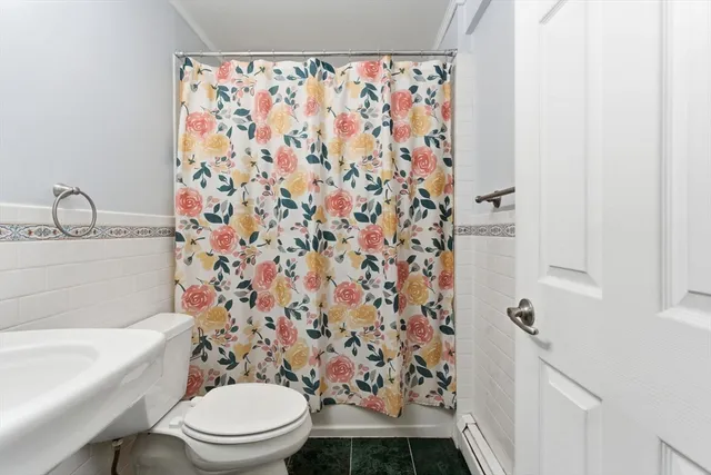 a white toilet sitting next to a shower curtain