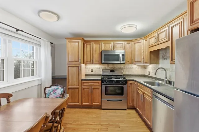 a kitchen with stainless steel appliances granite countertop a stove microwave and sink