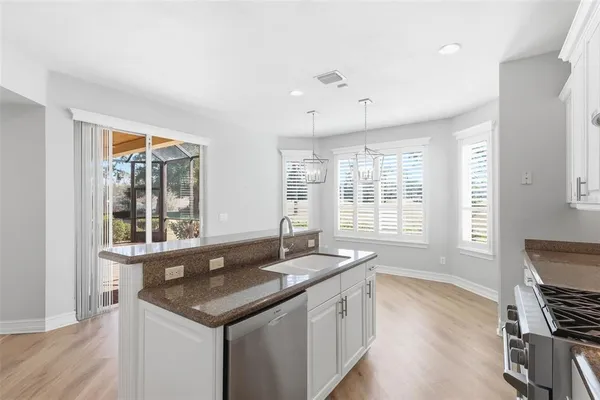 a kitchen with granite countertop a sink stove and cabinets