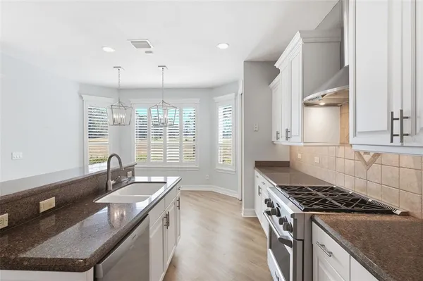 a kitchen with a sink stove and cabinets