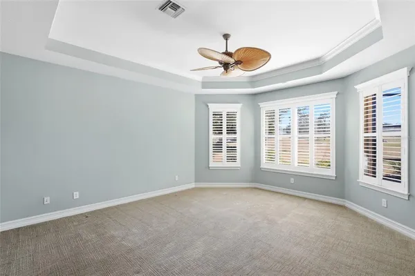 a spacious bedroom with a bed and a chandelier