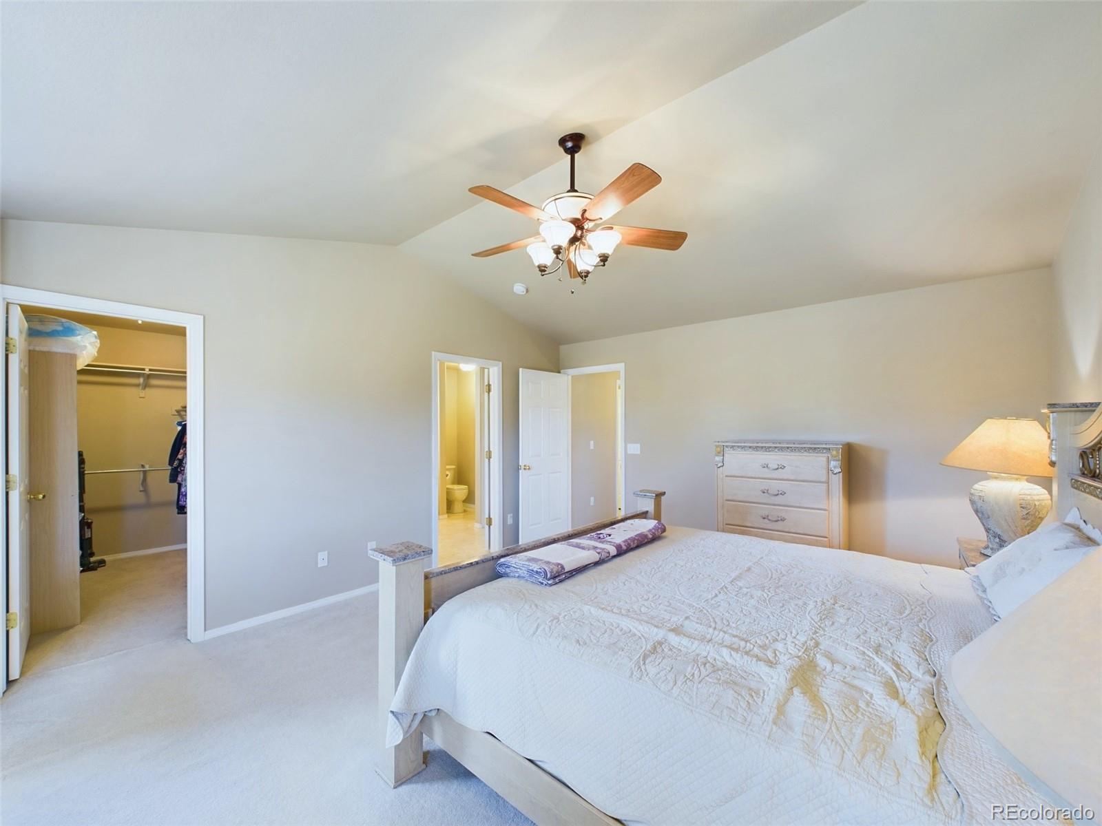 5140 Shoup Road Colorado Springs, CO 80908 - Photo 11 of 42 a bedroom with a bed and a chandelier