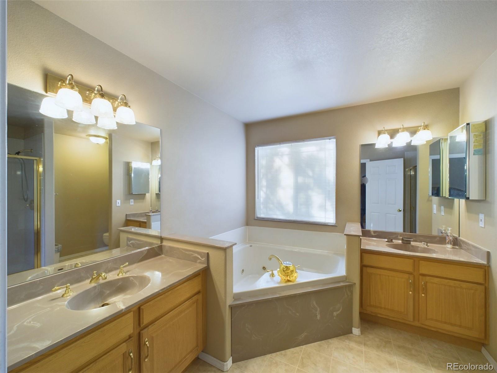 5140 Shoup Road Colorado Springs, CO 80908 - Photo 12 of 42 a bathroom with a tub sink and mirror