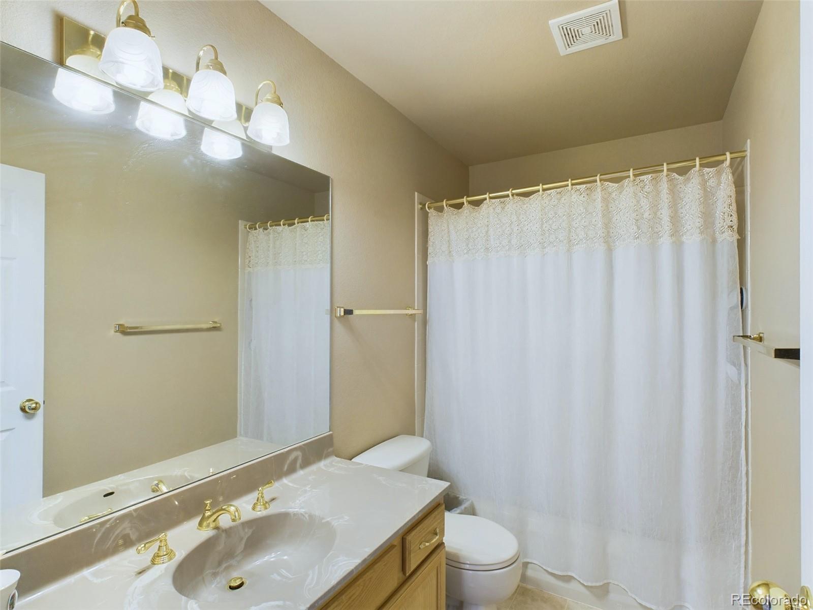 5140 Shoup Road Colorado Springs, CO 80908 - Photo 16 of 42 a bathroom with a sink a toilet and a mirror