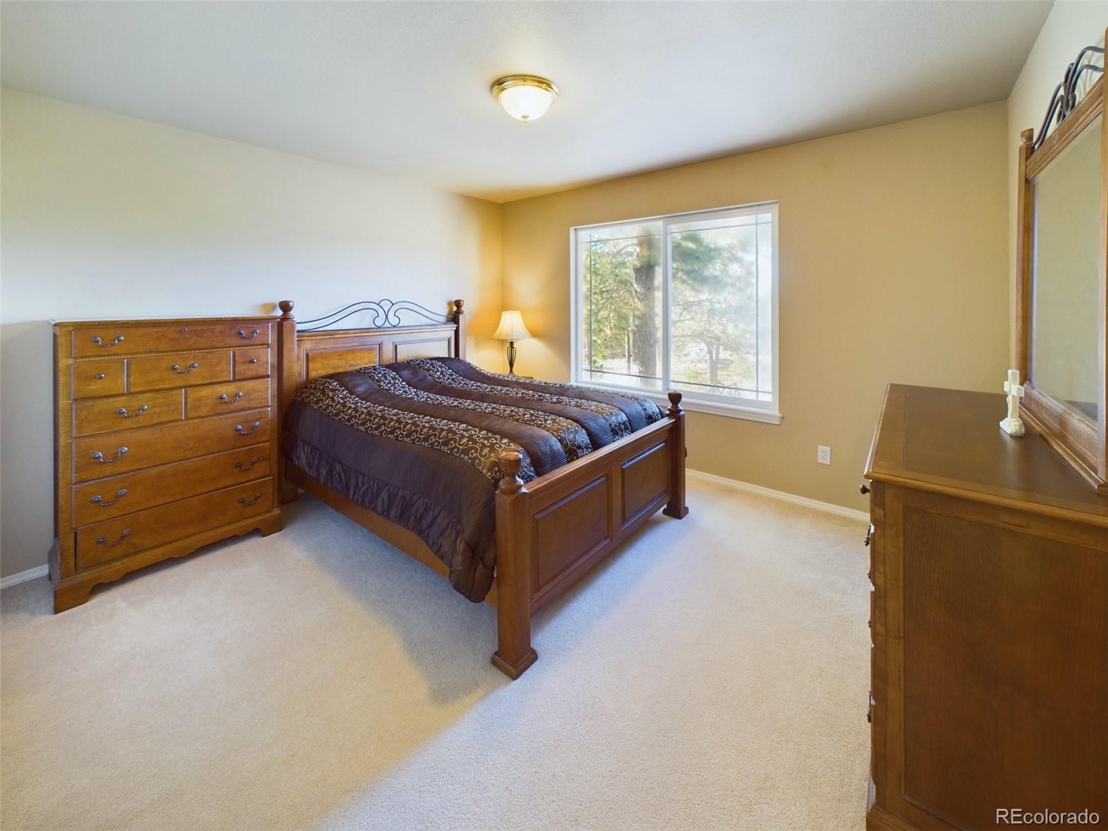 5140 Shoup Road Colorado Springs, CO 80908 - Photo 17 of 42 a spacious bedroom with a bed and a dresser