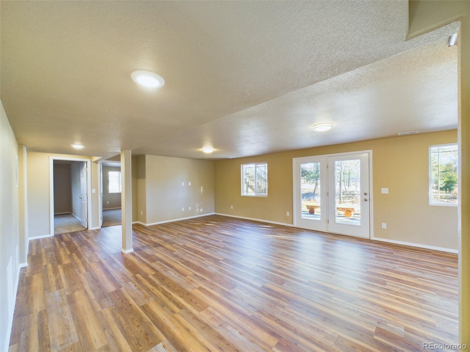 5140 Shoup Road Colorado Springs, CO 80908 - Photo 20 of 42 a view of an empty room with window and wooden floor