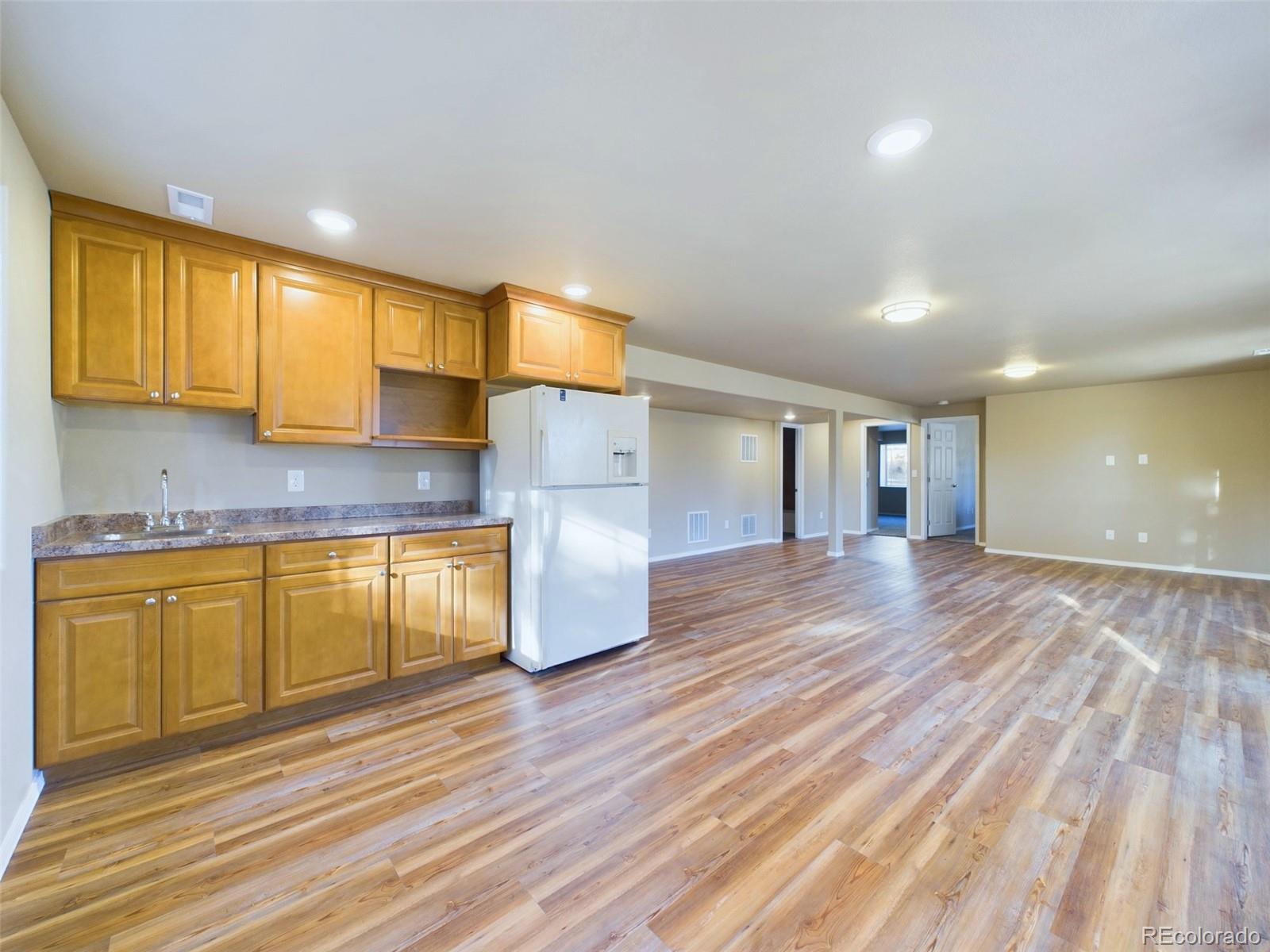 5140 Shoup Road Colorado Springs, CO 80908 - Photo 21 of 42 a kitchen with granite countertop wooden floors and cabinets