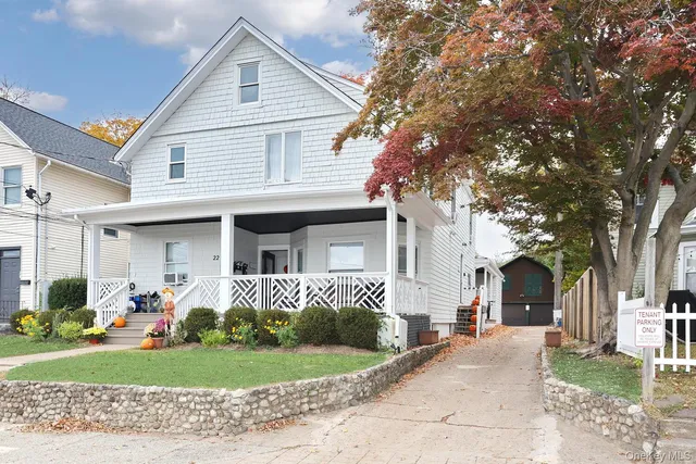 a front view of a house with a yard and potted plants