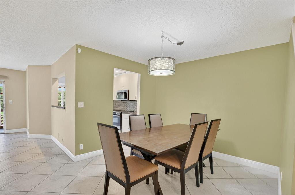 5051 Pointe Emerald Lane, Unit 5051 Boca Raton, FL 33431 - Photo 14 of 65 a view of a dining room with furniture and wooden floor