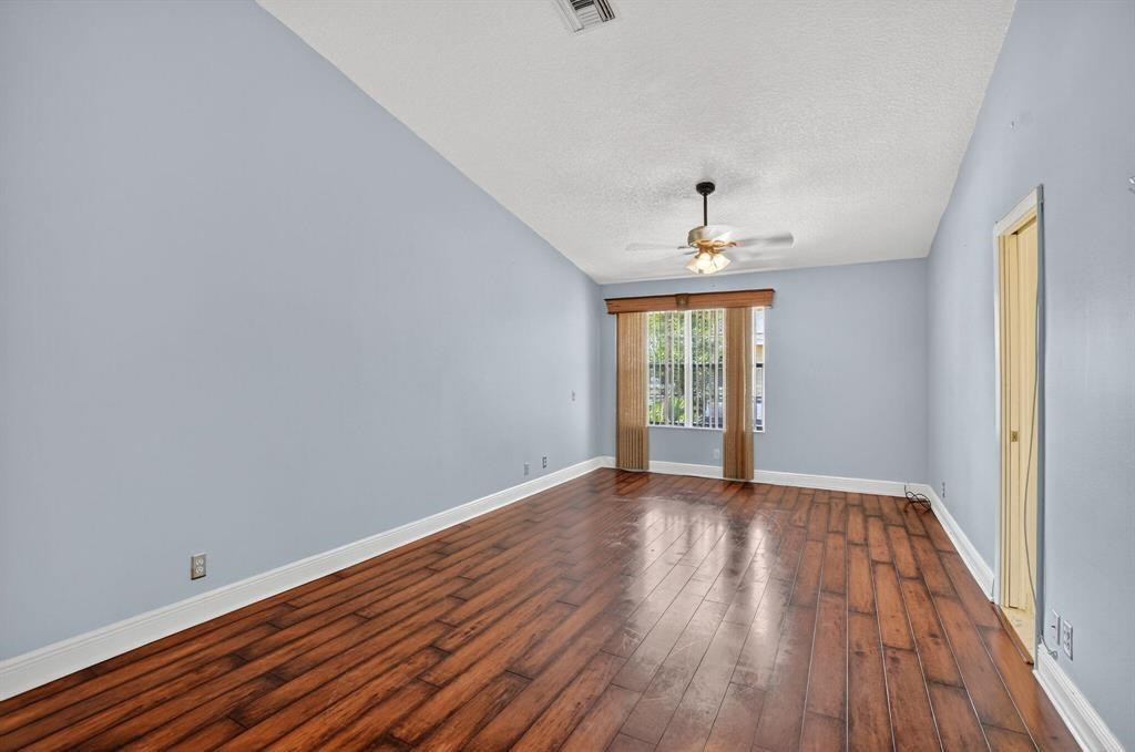 5051 Pointe Emerald Lane, Unit 5051 Boca Raton, FL 33431 - Photo 21 of 65 a view of an empty room with wooden floor and a window