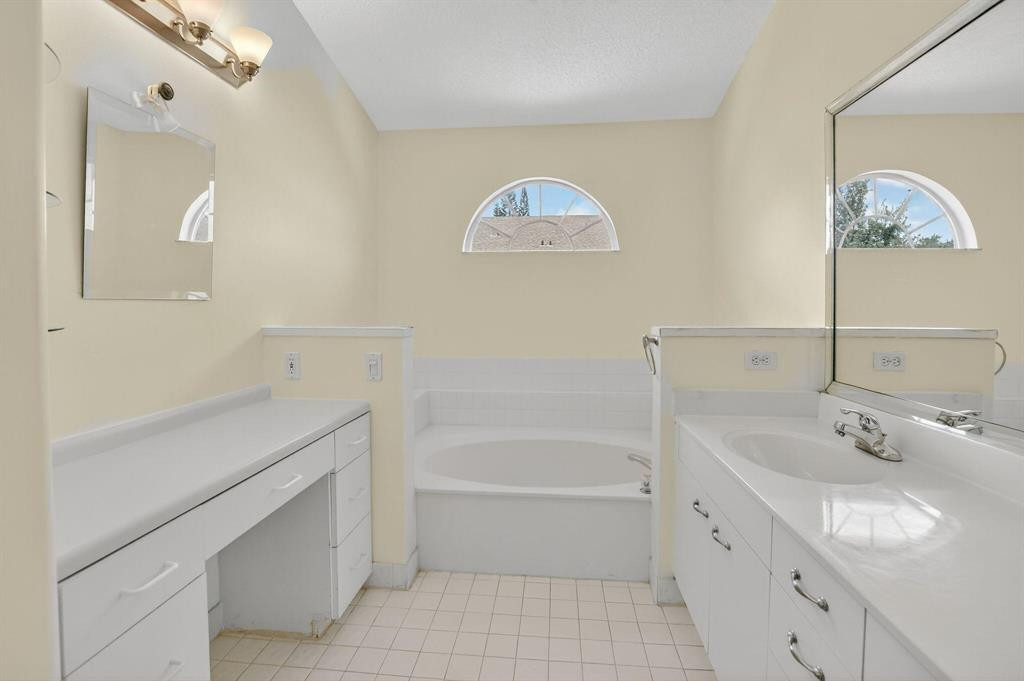 5051 Pointe Emerald Lane, Unit 5051 Boca Raton, FL 33431 - Photo 26 of 65 a bathroom with a tub sink and a mirror