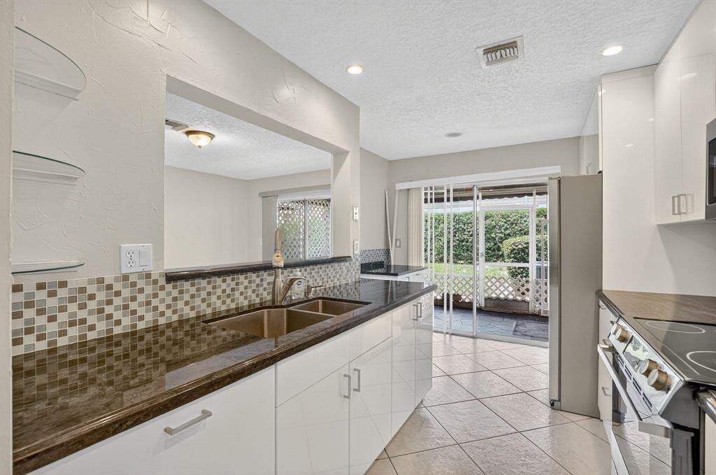 5051 Pointe Emerald Lane, Unit 5051 Boca Raton, FL 33431 - Photo 9 of 65 a large white kitchen with a large window