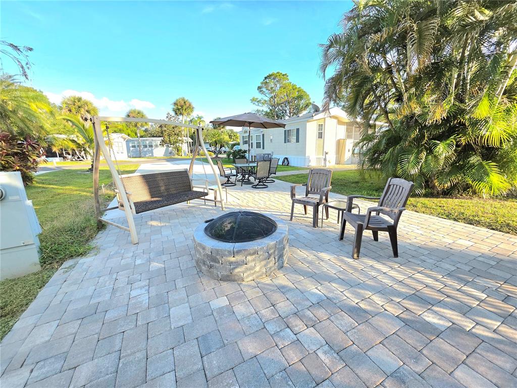 26 West Appaloosa Trail River Ranch, FL 33867 - Photo 7 of 9 a view of a patio with table and chairs potted plants and a large tree