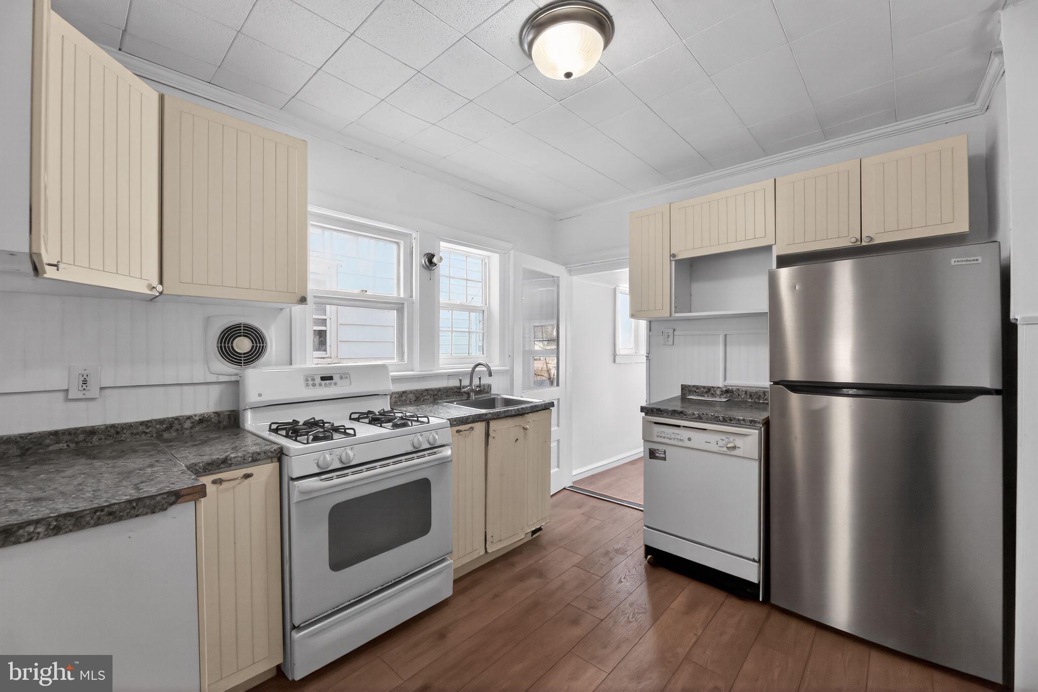 521 Bem Street Riverside, NJ 08075 - Photo 7 of 16 a kitchen with stainless steel appliances granite countertop a stove a refrigerator a sink a stove and white cabinets with wooden floor