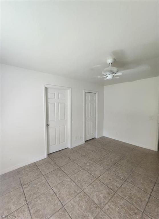 1854 55th Terrace Southwest Naples, FL 34116 - Photo 8 of 9 Tiled empty room featuring a ceiling fan and baseboards