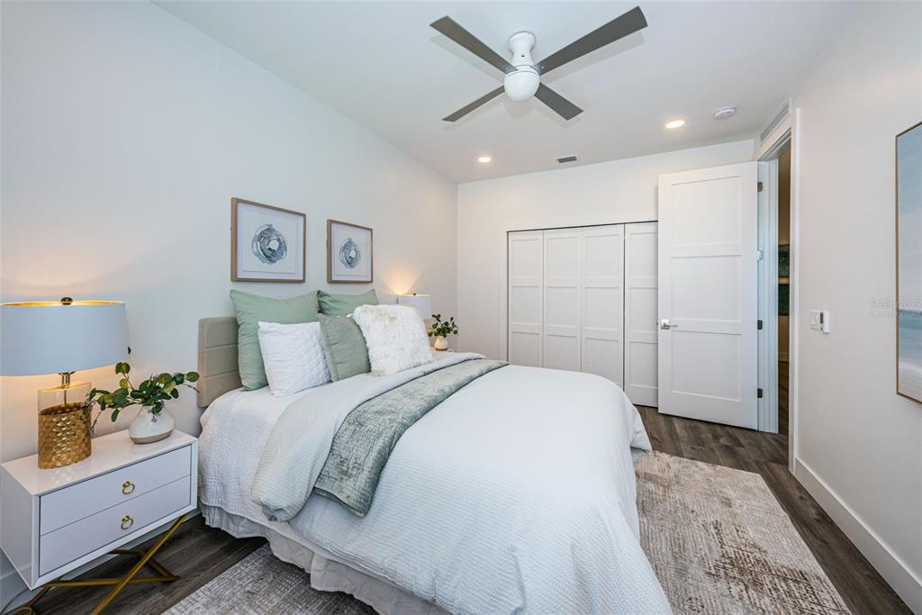 12305 3rd Street East, Unit 2 Treasure Island, FL 33706 - Photo 30 of 69 a spacious bedroom with a bed and a chandelier
