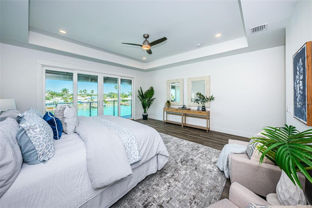 12305 3rd Street East, Unit 2 Treasure Island, FL 33706 - Photo 40 of 69 a spacious bedroom with a large bed chandelier and a window