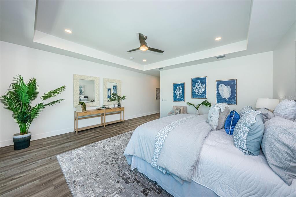 12305 3rd Street East, Unit 2 Treasure Island, FL 33706 - Photo 41 of 69 a spacious bedroom with a large bed and a potted plant